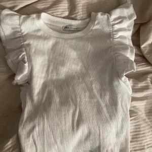 Zaratopp - Säljer denna söta topp från zara, aldrig använd🤍 Kontakta mig vid intresse, frakten tillkommer och är spårbar!