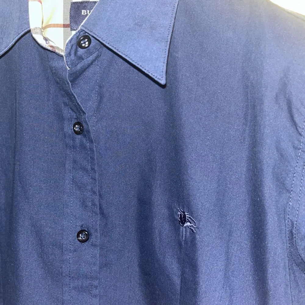 En stilig Burberry skjorta i mörkblått som säljs pga liten storlek. Använd endast ett fåtal ggr. Taggen säger S men passar även s/xs herr och M/S/XS för dam. Kan mötas upp i karlstad.. Skjortor.