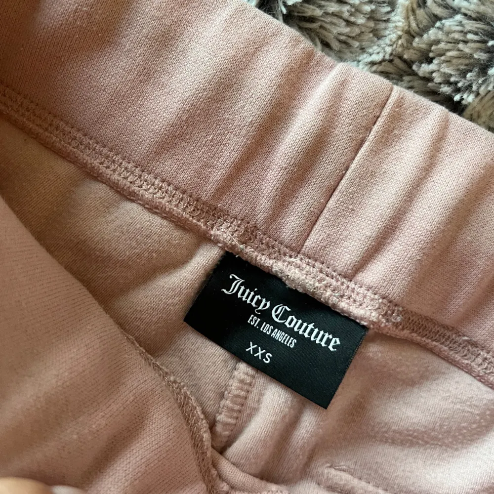 Jag säljer mina rosa juicy couture byxor som jag har använt flitigt, båda ringarna runt snörena är borta och därmed det låga priset. Säljer nu för dem inte kommer till användning så ofta längre🫰💗. Jeans & Byxor.