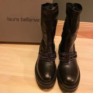 Ett par svarta skor i äkta skin med kedjor framtill från det populära märket Laura Bellariva. Storlek 39. Säljer på grund av felköp i storlek, har ALDRIG används. Originalpris: 3299kr