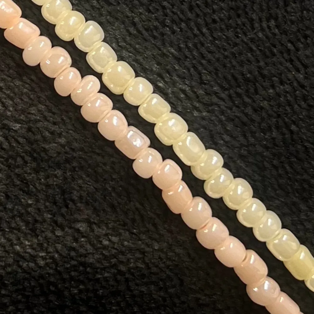 Egentillverkat pärlarmband i två rader med gula och aprikosfärgade pärlor och silvrigt spänne. Justerbar passform mellan 20-25 cm.. Accessoarer.