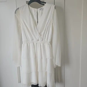 Vit studentklänning - En ganska enkel studentklänning från Bubbleroom med långa ärmar i spets och en kjol av volanger🤍 otrolig passform och mycket bekväm🌸 priset går absolut att diskutera