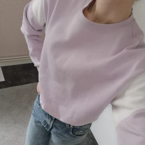 Collegetröja lila - En superfin collegetröja i en ljuslila färg och med vitt på ärmarna. I superfint skick förutom en liten fläck på ärmen (se bild 3). I storlek S. 