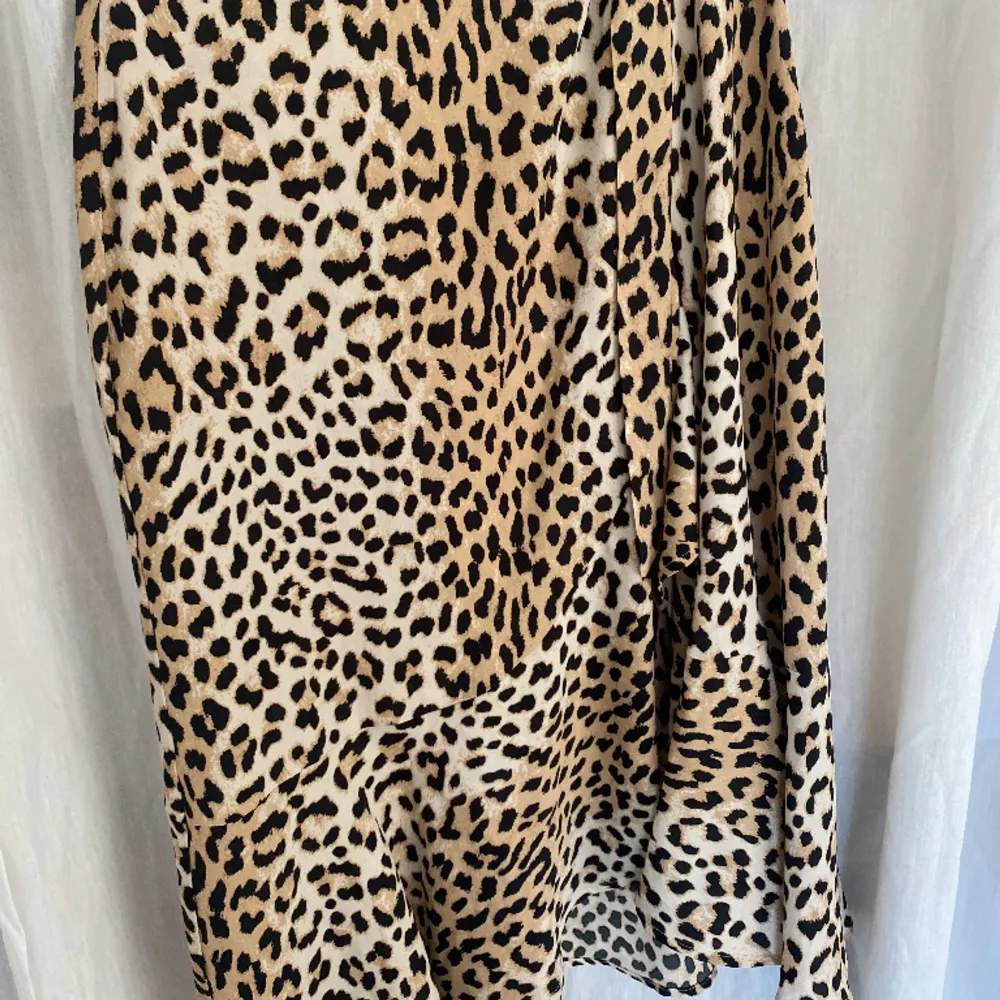 En lång kjol med leopardmönster som inte längre används! Knyts med ett band i midjan och har volang längs kanten. . Kjolar.