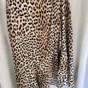 En lång kjol med leopardmönster som inte längre används! Knyts med ett band i midjan och har volang längs kanten. 