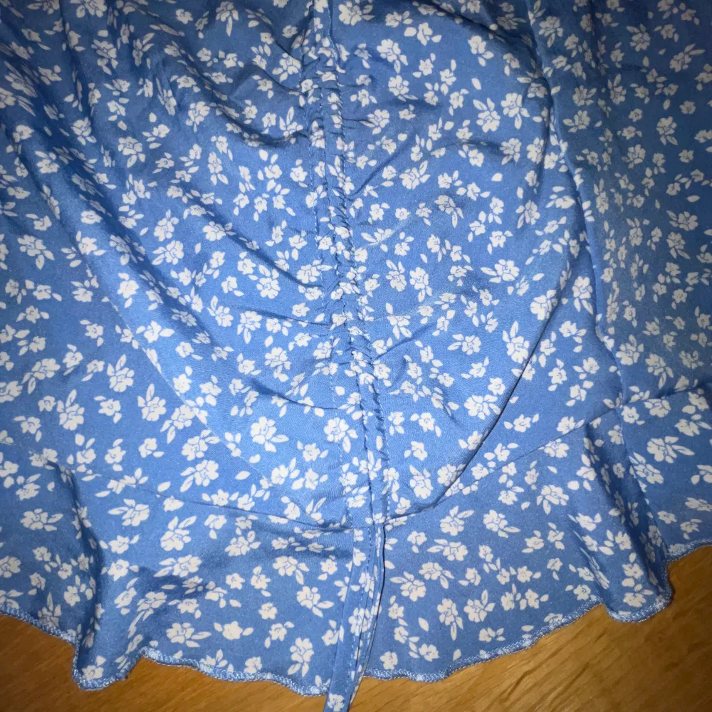 Säljer en blå kjol med vita små blommor på, köpt på Shein för 100kr säljer för 65kr för jag har aldrig använt den, lite liten i sin storlek!!. Kjolar.