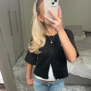 Kort stickad kofta / bolero  - Säljer denna mörkgråa korta kofta. Jag har satt fast den med en säkerhetsnål på bilderna. Har du någon fråga är det bara att höra av dig🫶🏻