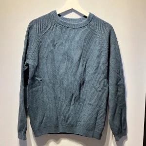 Stickad tröja  - Ribbstickad tröja från Dressman i en grönblå färg. Endast använd några fåtal gånger så i mycket fint skick. Storlek small. Svarar gärna på frågor