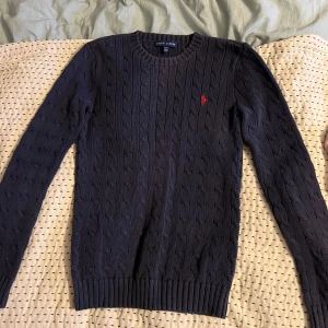 Kabelstickad tröja - En mörkblå kabelstickad tröja från Ralph Louren! Köpte denna av en annan säljare på plick tror jag så kommer inte ihåg nypris.  