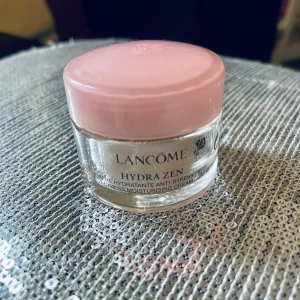 Lancome 15 ml Hydrazen  - Den snabbabsorberande och lätta Hydra Zen (Neurocalm) Cream återfuktar intensivt så att huden känns fräsch, mjuk och slät. Med sin blandning av extrakt från ros, pion, moringa och salicylsyra hjälper denna lugnande ansiktscreme till att synligt r