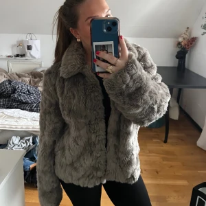 Fake fur jacka  - Grå fake fur jacka från VILA. Den är i storlek L men jag är en storlek S och den sitter som på bilderna på mig. Den är i fint skick förutom att en knapp ramlat av i mitten, den går dock ändå att stänga bra. 🤩☀️köpt för 700 kr, jag säljer för 200:)
