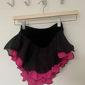 Konståknings kjol - Fin konståkningskjol från Jerry’s. Nyskick. Svart och rosa. Innertrosa. Endast använd två gånger. Storlek 10 - 12 år. Nypris 400kr jag säljer för 200kr. 