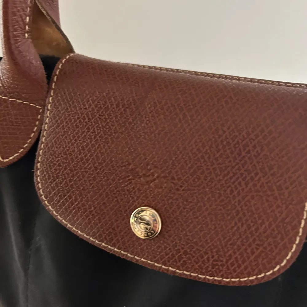 Superfin svart Longchamp väska med bruna detaljer, använd fåtal gånger. 🥰  Nypris: 1299kr. Väskor.
