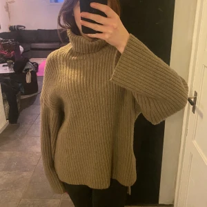 stickad tröja - Stickad tjocktröja med hög krage. Slits längst ner på sidan, lite längre på baksidan. Använd fåtal gånger och i väldigt bra skick!☺️