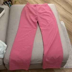Rosa byxor - Barbie-rosa byxor från sla the label använda 1 gång. Tightare vid låren och lösa/ utsvängda längst ner(se sista bilden). Säljer även matchande blazer och topp. 200kr för byxorna eller 400kr för hela kitet