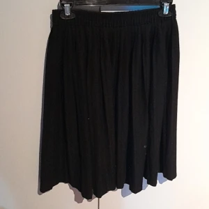 Svart kjol - En svart kjol, går precis ovanför knäna.