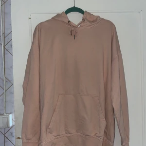 Beige hoodie från Urban Classics - Säljer en snygg och bekväm beige hoodie från Urban Classics. Den har en stor ficka på magen och en justerbar huva med dragsko. Perfekt för en avslappnad stil och passar bra till både jeans och joggers. Hoodien är i bra skick och redo för en ny ägare!