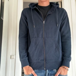 Zip Hoodie  - Säljer nu en marinblå zip hoodie för endast 200kr från Jack & Jones. Skicket är 9,5/10 använd en gång. Chill zip hoodie som passar till typ allt. Storleken är Medium. Skriv vid frågor eller funderingar. 