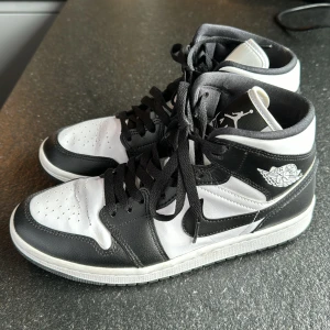 Svartvita Nike Air Jordans - Säljer ett par snygga svartvita Nike Air Jordans i bra skick. Skorna har en klassisk design med svart och vitt läder, och de ikoniska Air Jordan-loggorna på sidan och tungan. Perfekta för både vardag och fest!