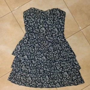 Blommig axelbandslös klänning - Säljer en superfin axelbandslös klänning med blommigt mönster. perfekt sommarklänning!🥰