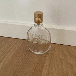 Parfym från Diesel - Säljer en stilren parfymflaska från Diesel. Flaskan är genomskinlig med en guldig kork och har en oval form. Perfekt för både vardag och fest! Köp direkt eller ge prisförslag 💛