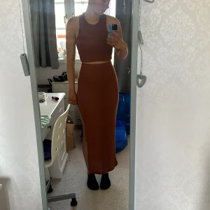 Brun långklänning från Shein - Säljer ett snyggt brunt set från Shein. setet  har en tight passform med en slits på sidan. Perfekt för sommarens fester eller en dag på stan. Materialet är mjukt och bekvämt, och den har en ribbad struktur som ger en extra touch av stil. Köp direkt eller ge prisförslag 💛