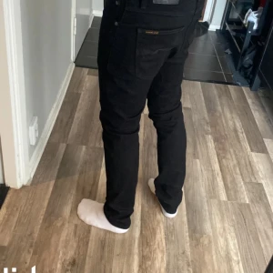 Svarta jeans från Nudie Jeans - Säljer dessa svarta Grim Tim Nudie Jeans med riktigt skön passform i nyskick till ett dunder pris! Kostar 1300 nya. Färgen är Ever Black. Tveka inte på att höra av dig vid frågor eller funderingar?