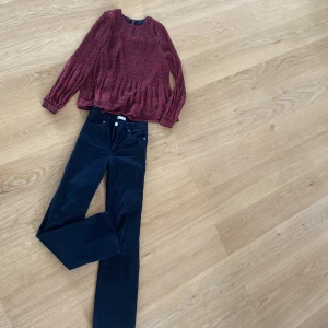 Svarta manchesterbyxor från Lindex - Säljer ett par svarta jeans från Lindex i storlek EUR 34/UK 8. Byxorna är högmidjade och har en straight passform. Perfekta för höst och vinter, och kan stylas både uppklätt och nedklätt. De är i bra skick och redo för en ny ägare! mönstrad blus ingår 