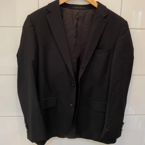 Hugo Boss kavaj - Använd endast några gånger. Fint skick. Kan ej se storleken men passar om du har storlek S (möjligt storlek M). Jag har storlek M/L och den sitter lite tight på mig. Se bild.   Svart kavaj med tunna ränder. 