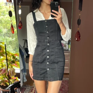 Svart button-up jeans klänning  - Säljer denna snygga svarta button-up jeans klänningen som kan stylas på flera sätt!🤩 Knapparna är äkta och går att öppna upp. Använd ett fåtal gånger. Säljs pågrund av att det inte används längre. Kontakta mig vid frågor eller intresse ❤️