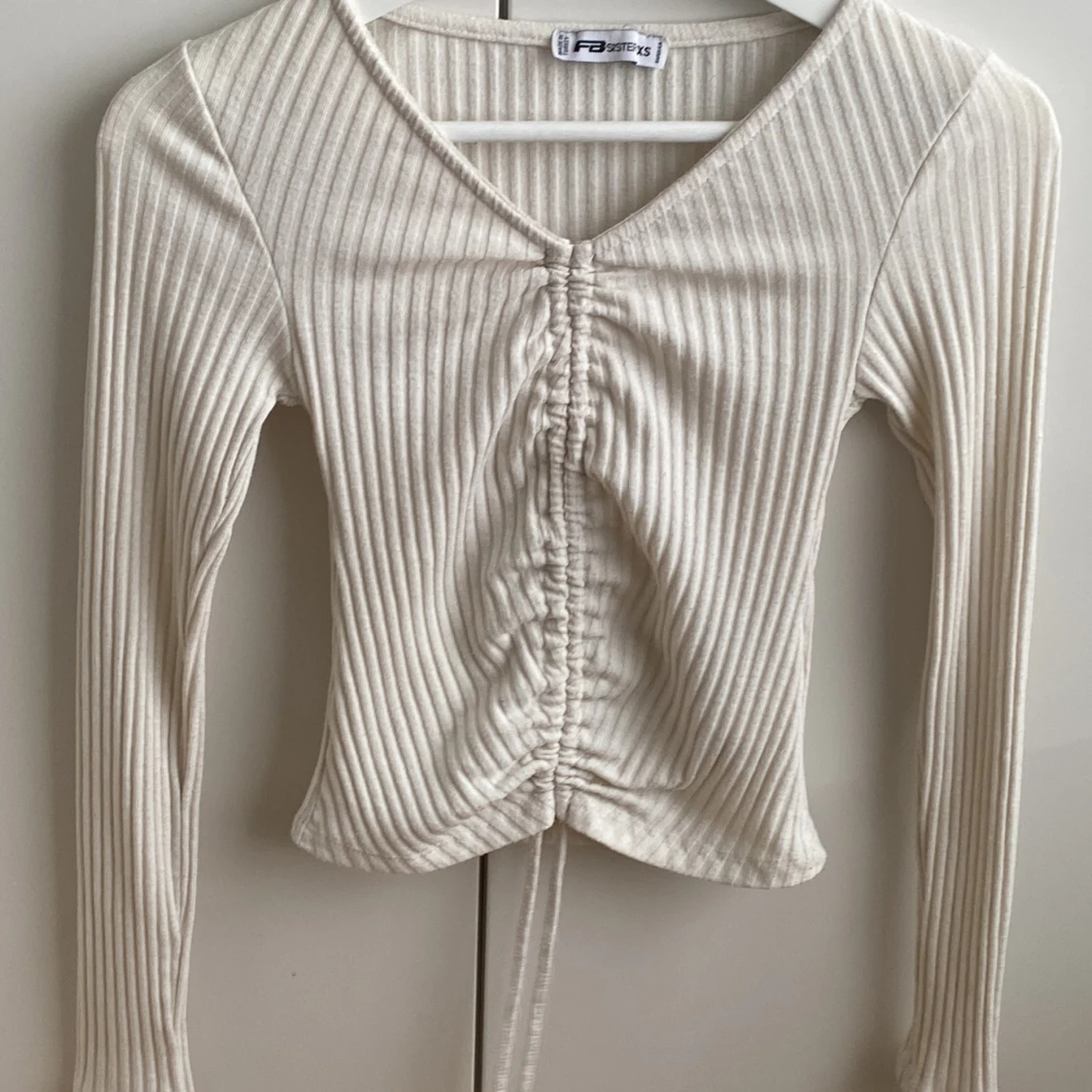 Smutsig vit lite randig långärmad tröja