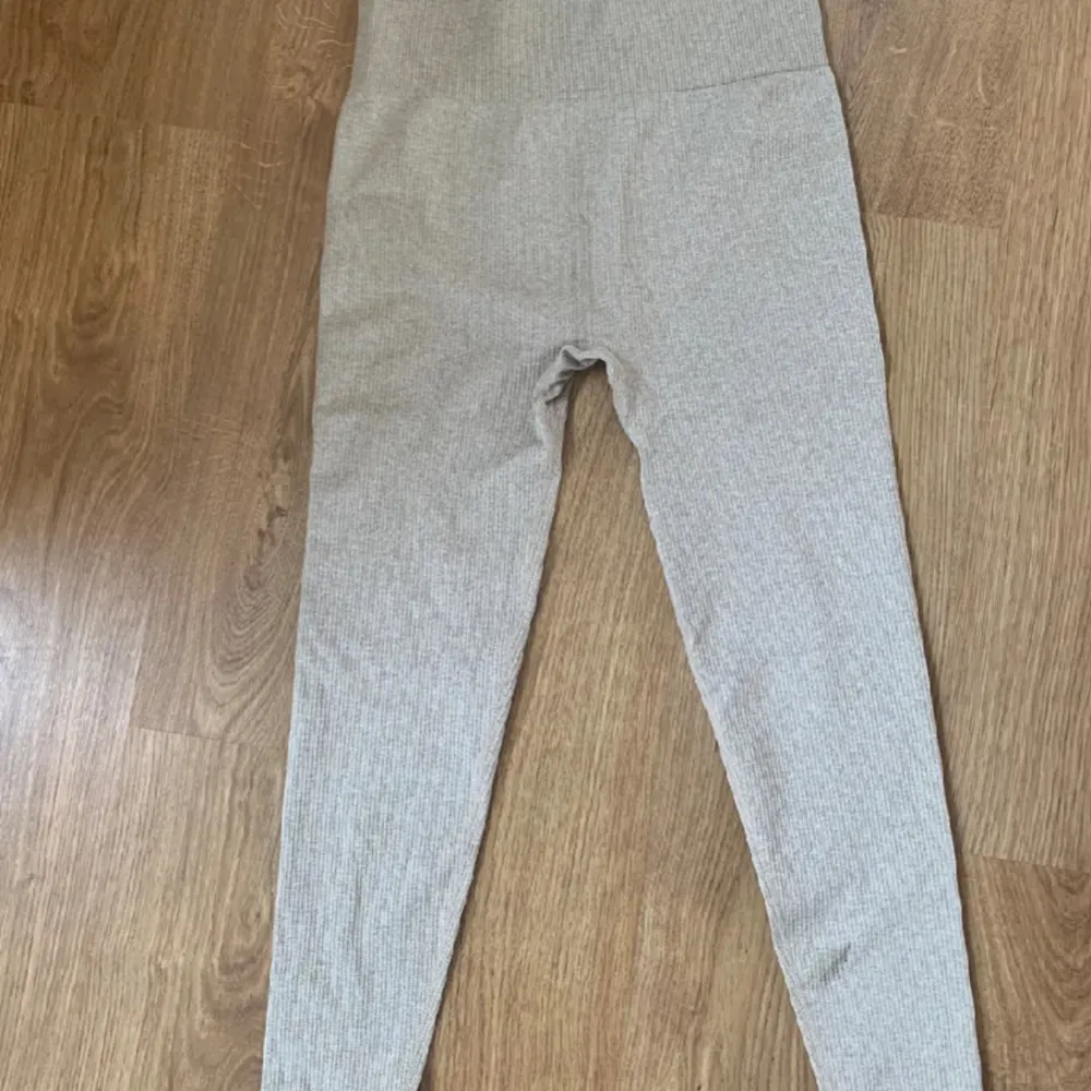 Ett par HELT OANVÄNDA beige leggings från New Apparel i storlek L. Leggingsen har en ribbad struktur och hög midja för en bekväm passform.. Jeans & Byxor.