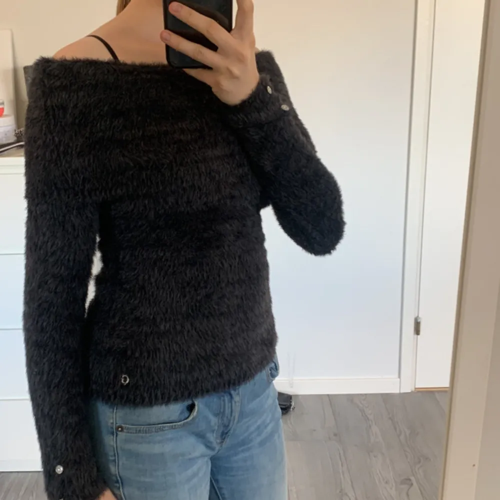 Snygg stickad off shoulder tröja från Guess i nyskick med snygga detaljer. Köpt för 800kr och endast använd fåtal gånger så ser helt ny ut.. Stickat.