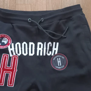 Svarta mjukisbyxor från Hoodrich - Svarta mjukisbyxor från Hoodrich med tryck och broderade detaljer. Byxorna har en dragsko i midjan och är tillverkade av 80% bomull och 20% polyester.