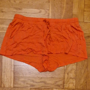Korallfärgade shorts - Färgstarka, luftiga shorts från H&M basic. Mycket sköna på varma dagar eller som pyjamas. Okej att komma med egna bud. Katt i hemmet. 
