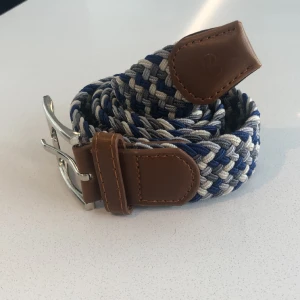 Flätat bälte  - Flätat bälte ljusgrå mörkgrå blå vit  | stretch och anpassningsbar till alla storlekar | helt nytt aldrig använt | skriv om du har frågor. 