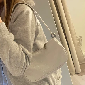 Liten axelväska - Jättefin liten vit väska som bara kommit till användning 1 gång. Priset går att diskuteras. 