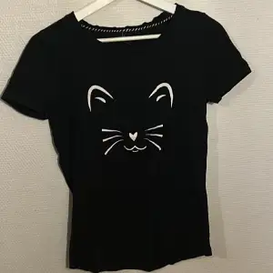 Svart T-shirt med katt tryck, nästan aldrig använd.