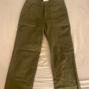 Gröna cargobyxor  - Säljer dessa snygga cargobyxor från H&M. Inte använts mycket så dom är i bra skick. För mått/fler bilder eller frågor kom privat! OBS! Alla plagg jag lägger ut tvättas innan jag skickar iväg dom.