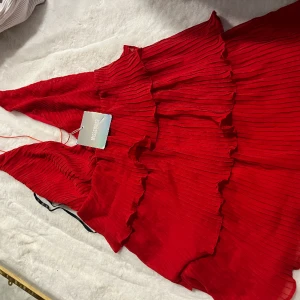 Röd miniklänning med volanger  - Ny lappar kvar  