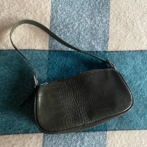 Olivgrön väska från ginatricot - En jättefin handväska i olivgrön från Ginatricot! Använd ett fåtal gånger men säljer pga att jag inte använder den längre🫶fint skick! 