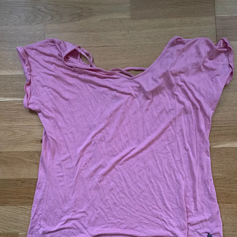 Lättsam rosa tröja med nästan öppen rygg bra o ha vid träning men funkar även om man vill gå för något färgglatt . T-shirts.