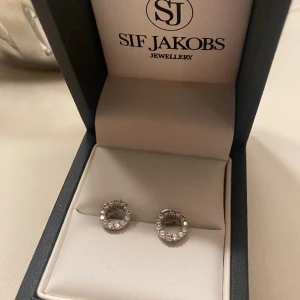 Oanvända örhängen i 925 sterling silver - Helt oanvända i äkta silver och vita zirkoner från SIF Jakobs Jewellery. Diameter 8 mm.  Kommer i originalask. Inklusive frakt.  Originalpris 849 kr.