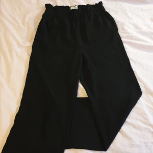 Svarta kostymbyxor - Ett par kostymbyxor med fin resår i midjan. Ganska lös passform. Passar mig perfekt i längden som är ca. 168 cm. 