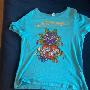 Ed Hardy tröja  - Säljer denna jättefina tröjan pgd av den är för stor på mig  rhinestones har trillat av,skulle säga den passar som S sickar bild om ni vill se hur många som har trillat av 