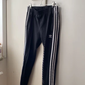 Adidasbyxor - Adidasbyxor som är lite dressade och raka i benen. Har dragkedja vid bensluten. Uk storlek 6, Us XS