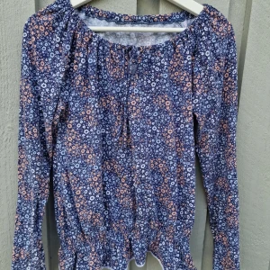 Blommig tröja  - Långärmad tröja med blommigt motiv. Stl M, lapparna bortklippta. Utan anmärkningar annars