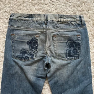 Fina vero Moda jeans - Säljer mina jättefina Jeans från vero Moda med blå broderier på då de tyvärr är lite för små på mig Innerbenslängd: 80cm Midja rakt över: 41cm (de är väldigt lågmidjade) Kontakta gärna för fler bilder eller frågor💗 pris kan alltid diskuteras!