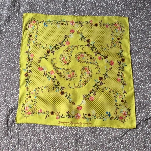 Sidenscarf från Stine Goya. - Gul, blommönstrad scarf i siden från Stine Goya. 100%siden, ca 42x42 cm. Fint använt skick.