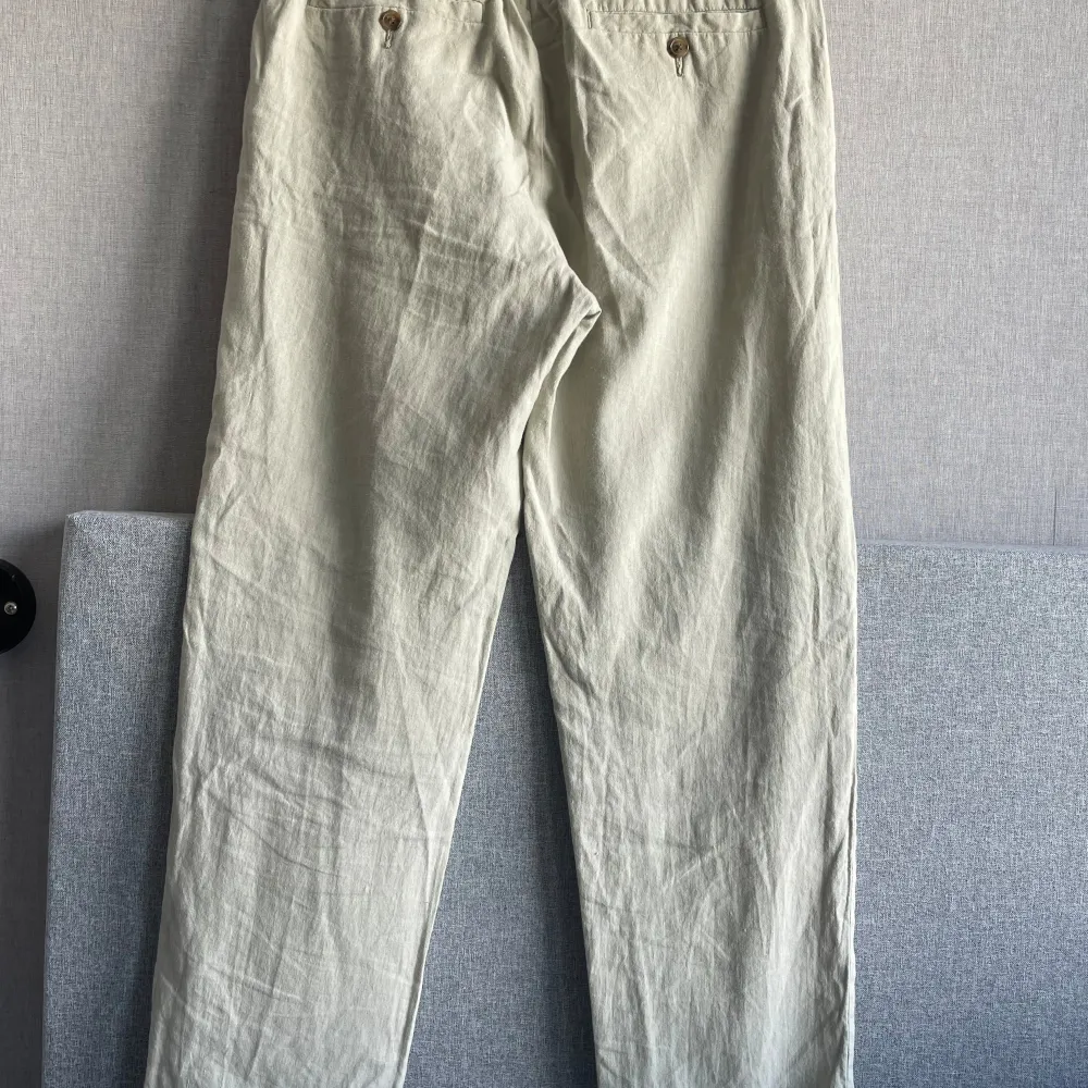 Ett par beige linnebyxor från H&M i storlek S. Byxorna har en regular fit och är tillverkade i ett lätt och bekvämt material. Köpta sommaren 2023, använd fåtal gånger. . Jeans & Byxor.